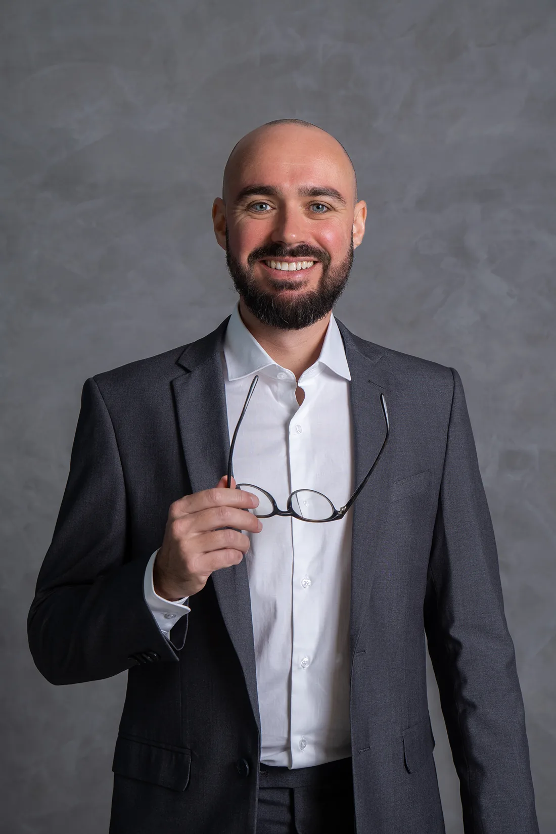 Dr. Renato Susin sorrindo, com os óculos na mão